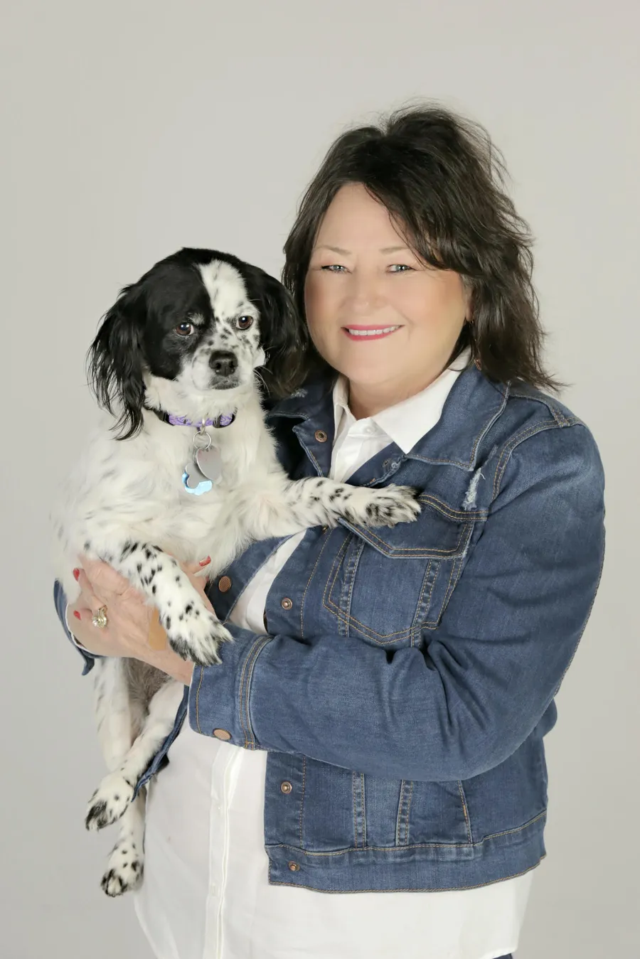 Sylvia Murphy, a Broken Bow native, holding her black-and-white spaniel